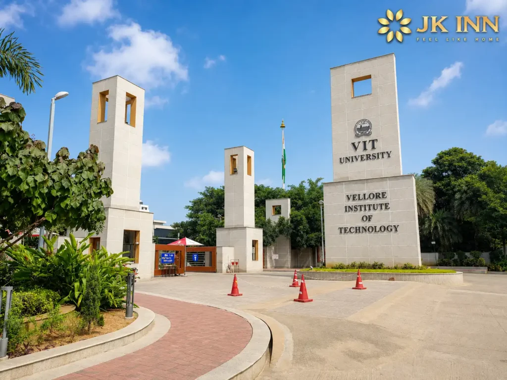 VIT Vellore (Vellore Institute of Technology) main entrance with JK Inn Vellore logo displayed in the top-right corner, showcasing the university campus and a nearby accommodation option for students and visitors.