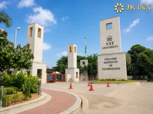 VIT Vellore (Vellore Institute of Technology) main entrance with JK Inn Vellore logo displayed in the top-right corner, showcasing the university campus and a nearby accommodation option for students and visitors.